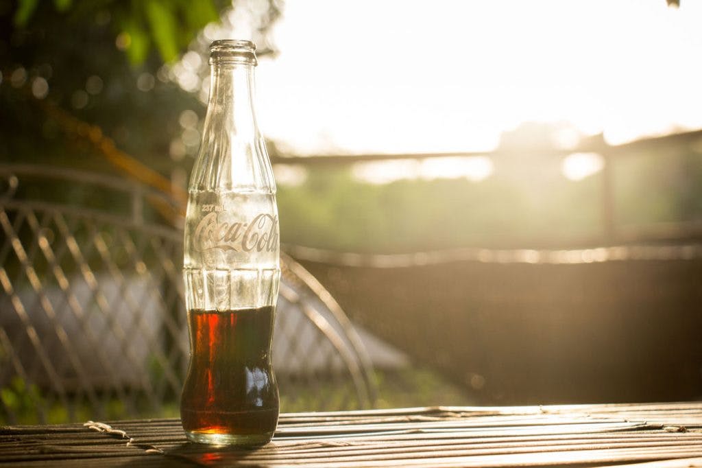 coca-cola glass bottle on a table outside
